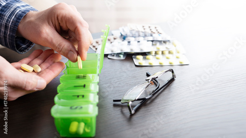Middle aged caucasian man distributing scheduled dose of medication in dosette box