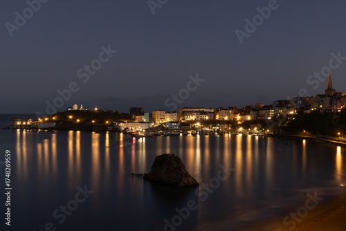 Tenby harbour, Pembrokeshire, Wales, at night with lights reflecting on the water