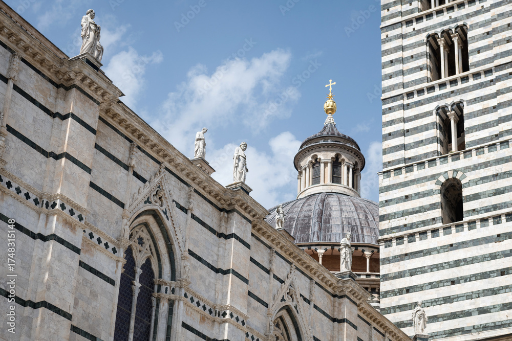 Obraz premium Marble statues on front of the 14th century Duomo di Siena, Italy. UNESCO World Heritage Site.