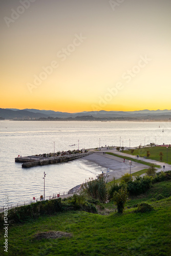 Wallpaper Mural A high-angle view of the Explanada de Gamazo waterfront promenade in Santander, Spain, during a beautiful golden hour sunset over the bay and mountains. Torontodigital.ca
