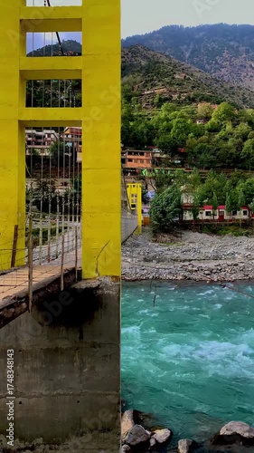 A panoramic view and close-up perspective of a vibrant yellow suspension bridge crossing the turquoise Swat River, framed by the lush, towering mountains of Khyber Pakhtunkhwa, Pakistan.
