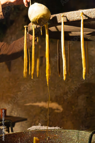 A scene from a historical reenactment where a chandler is making candles using medieval techniques. Warm light fills the rustic workshop, dripping from the wicks.