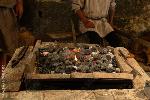 The glowing heart of a medieval smithy. The intense heat of the burning embers is ready to shape metal. An authentic scene of an ancient craft.