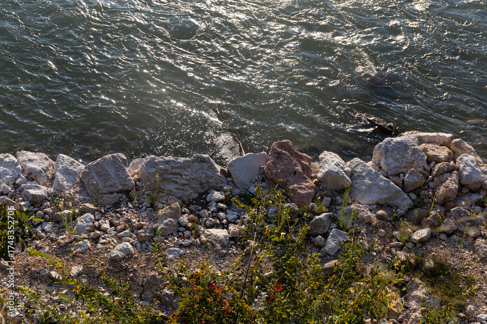 Obraz premium An abstract natural texture of shimmering river water and rugged stones. Perfect as a background for concepts of environment, power, and purity.