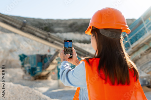 Obraz na plátně Female construction worker holding mobile phone taking photo at quarry site