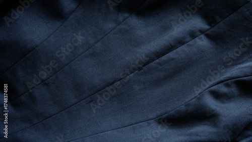 Black clothing background of stitches texture of back of suit jacket. Close-up black-gray jacket texture. Concept of abstract, crumpled, tailors, textiles, fabric for fashion, garment, print.