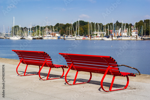 Fototapeta Naklejka Na Ścianę i Meble -  Red street bench in front of the Baltic sea, Röstock, Germany
