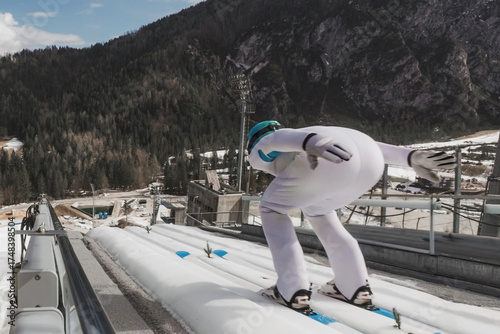 Photos Ski jumper running down the ski jump. Winter tournament concept.