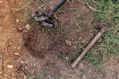 A metal detector and a small excavation pick, photographed close-up.