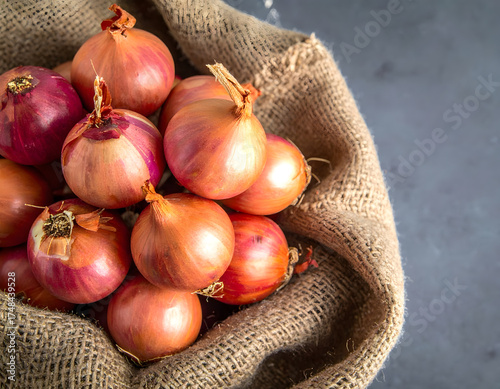 Fresh onions spilling out of a burlap sack