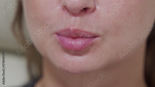 A close-up captures a woman puckering her lips, suggesting she's about to make a kissing sound.