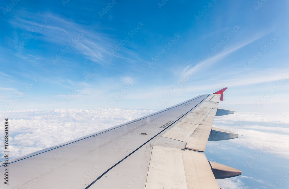 Obraz premium View from the airplane window at a beautiful cloudy sky and the airplane wing