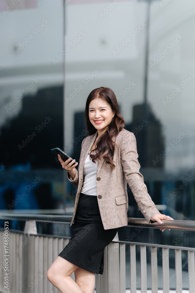 Fototapeta premium Confident Businesswoman Using Smartphone Outdoors