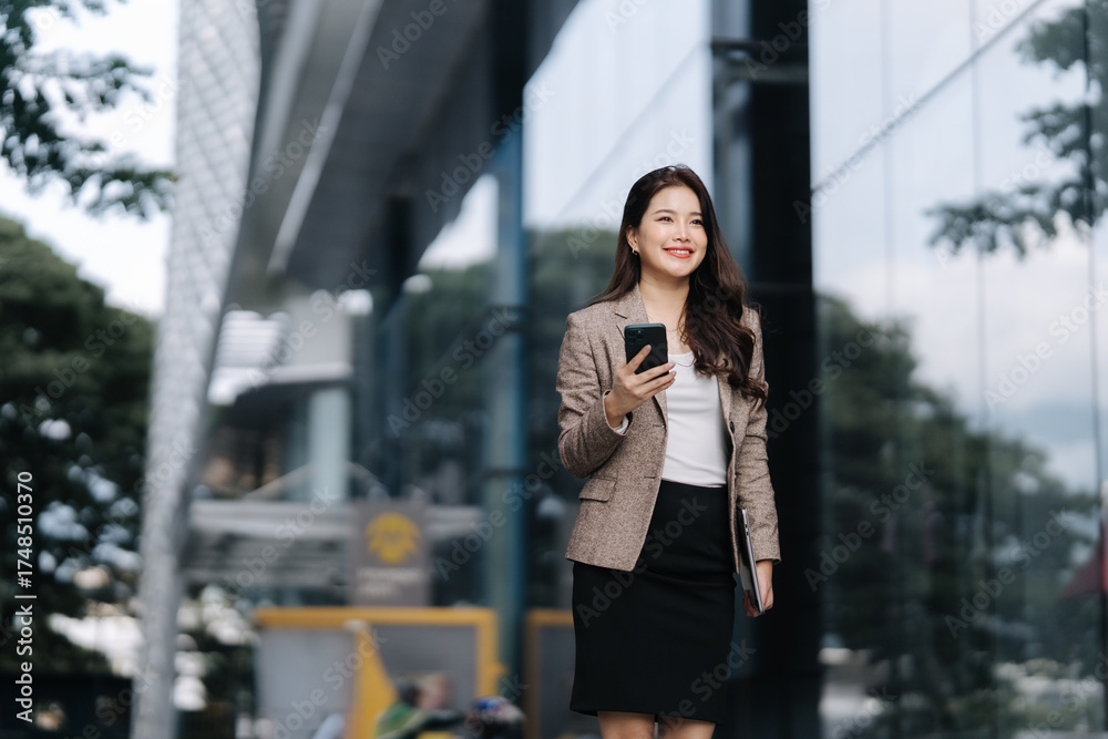 Fototapeta premium Businesswoman's Urban Stroll: A sophisticated businesswoman strides confidently through a modern cityscape.