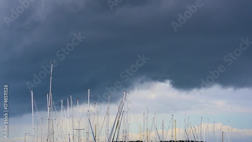 Dark storm clouds over marina sailboat masts