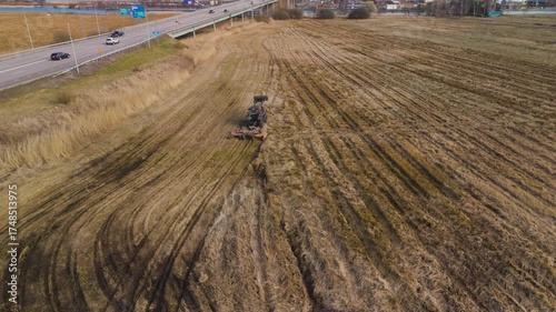 Agricultural tractor working on muddy grass field