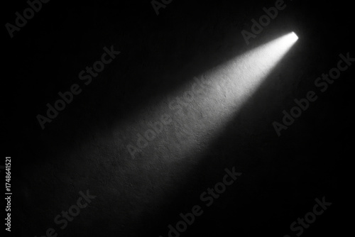 A solitary beam of light cuts through the darkness, illuminating a small area. The stark contrast between light and shadow creates a dramatic mood.AI generated.