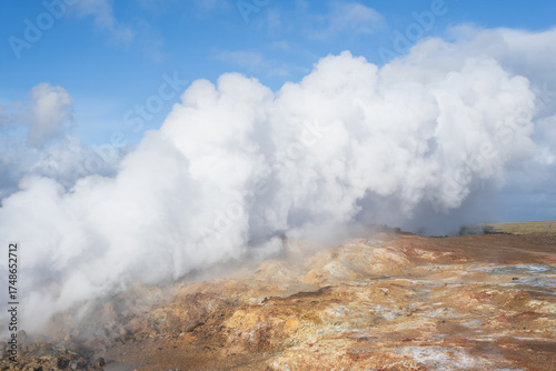 Fotografía Steam rising from geothermal area with colorful mineral deposits and rocky terra