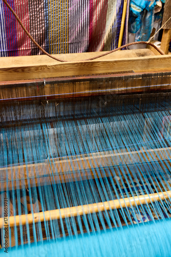 Artisans in Morocco use a loom to create colorful textiles. The intricate patterns and vibrant threads showcase traditional weaving techniques, reflecting the rich cultural heritage
