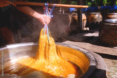 Photography Artisans' hands dyeing silk threads with natural ingredients inside of workshop
