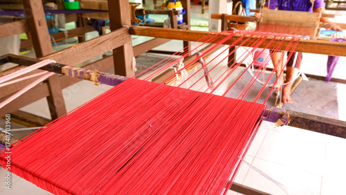Bild auf Leinwand Close-up of traditional handloom weaving with bright red threads, showcasing Tha