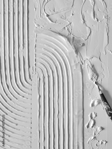 The process of making a painting from white  structural paste using a spatula