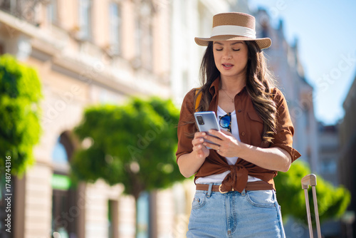 Foto Woman tourist traveling navigating city street using phone