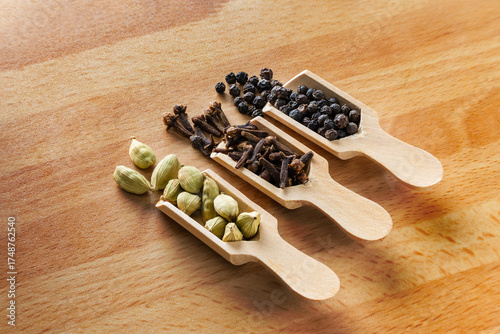 Three common spices cardamom,clows,and black peppercorns.