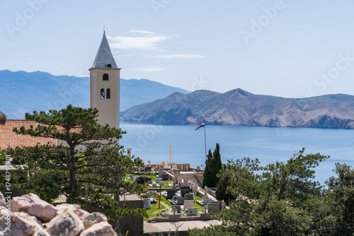 Baška, Croatia - April 20, 2025: View of the town cemetery with views of the sea and mountains