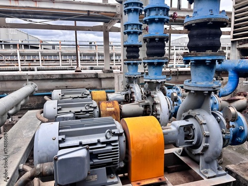 Industrial water pump system with connected pipelines and electric motors, used for fluid distribution and cooling in a factory or large facility.