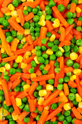 Cooked mixed vegetable background detail including carrots, peas and sweetcorn