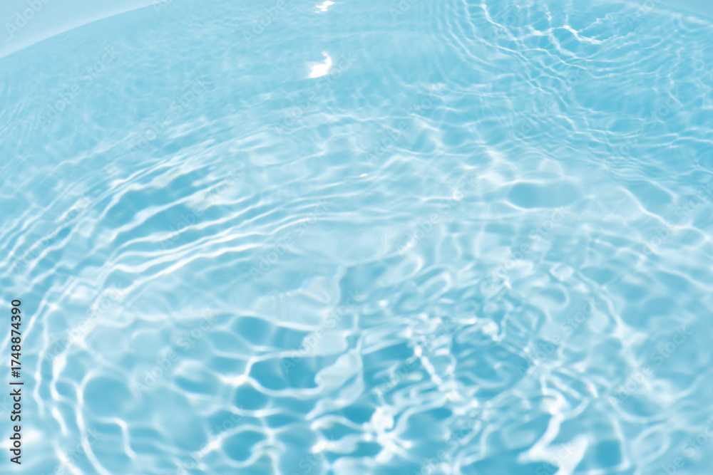 Obraz premium Blue water with ripples on the surface. Defocus blurred transparent blue colored clear calm water surface texture with splashes and bubbles. Water waves with shining pattern texture background.