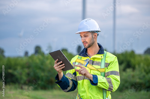 Male man engineer inspection by tablet gesture check control wind power machine out door wind energy factory. technician professional worker check wind power machine turbine field inspection