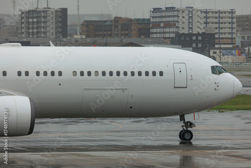 Close-up view of a commercial airplane cockpit and nose section at an airport. A pilot is preparing for flight, representing the aviation and travel industry.