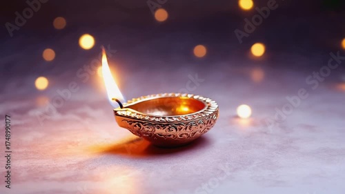 Burning diya oil lamp on dark background with bokeh