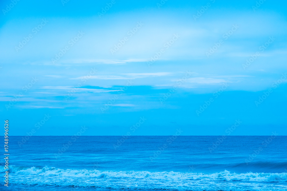 Fototapeta premium Nature of the ocean and blue sky Summer with sunshine, sandy beaches, clear blue waters sparkling against the blue sky. on an island with good ecology and environment Background for summer vacation