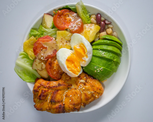 Buddha bowl with chicken, avocado, tomato and quail eggs