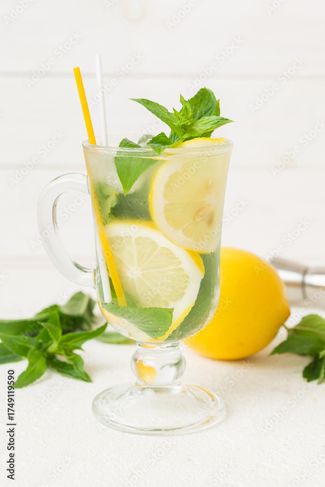 Fototapeta premium Mojito cocktail. Refreshing mojito cocktail with lime, lemon and mint in a tall glass with a stick