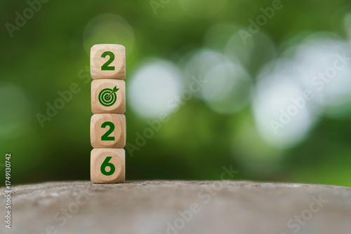 Happy new year 2026 background. 2026 Numbers and target icon on wooden blocks with green nature background. Business growth, setting goal and resolution to success plan concept.