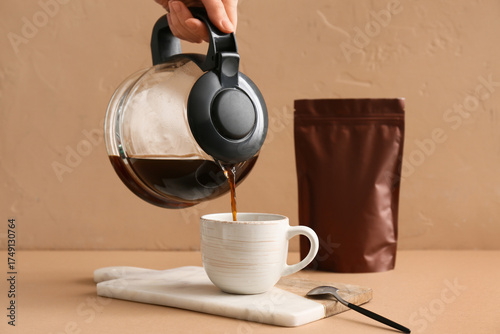 Woman pouring hot coffee fr...