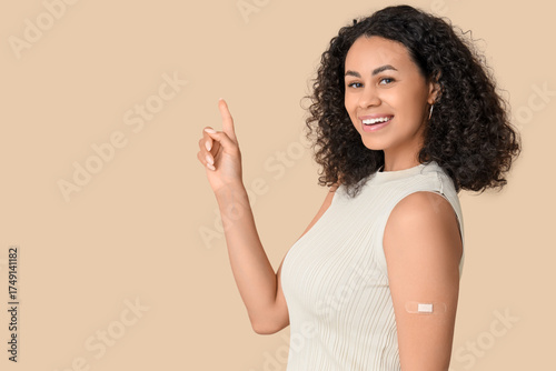 Принти на полотні Beautiful young happy African-American woman with applied medical patch pointing
