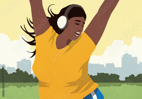 Happy, energetic young woman with headphones listening to music and dancing in sunny city park
