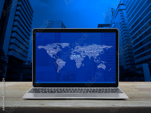 Fototapeta Naklejka Na Ścianę i Meble -  Start up 2026 business icon with global words world map on laptop computer screen on table over city, Happy new year 2026 global business start up online, Elements of this image furnished by NASA