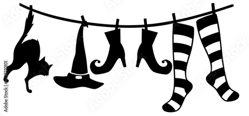 Halloween clothesline with black cat, witch hat, curled boots and striped stockings hanging to dry