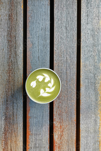 A cup of green tea matcha latte on wooden background                