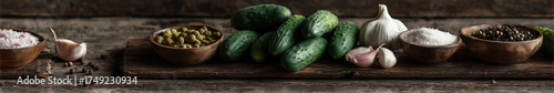 A flat-lay of pickling ingredients (cucumbers, garlic, dill, spices) on a wooden cutting board,  top-down view.