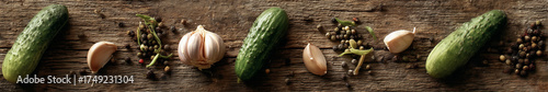 A flat-lay of pickling ingredients (cucumbers, garlic, dill, spices) on a wooden cutting board,  top-down view.