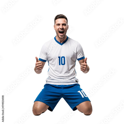Triumphant football player on his knees, cheering with excitement and giving a thumbs up gesture after scoring a decisive goal