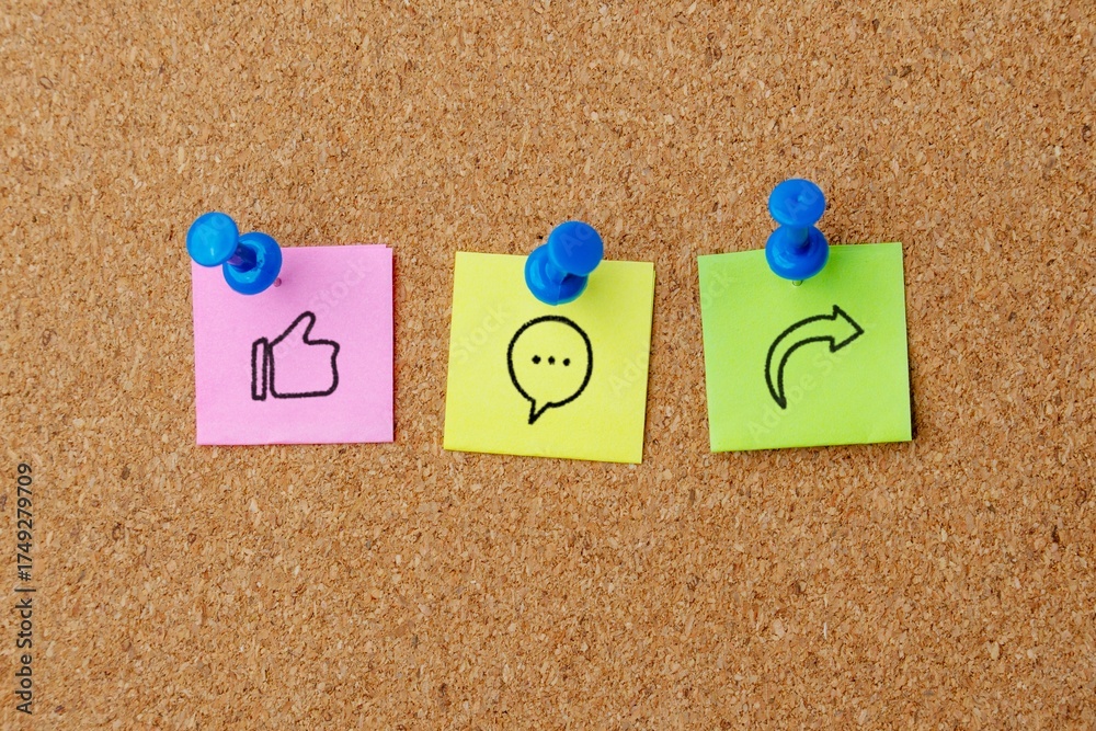 Obraz premium Notes pinned to a corkboard display social media icons for Like, Comment, and Share. Social media marketing, engagement, feedback, and online interaction concept.