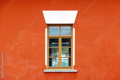 Wallpaper Mural Bold orange wall frames a classic wooden window with glass panes. Photo texture Torontodigital.ca